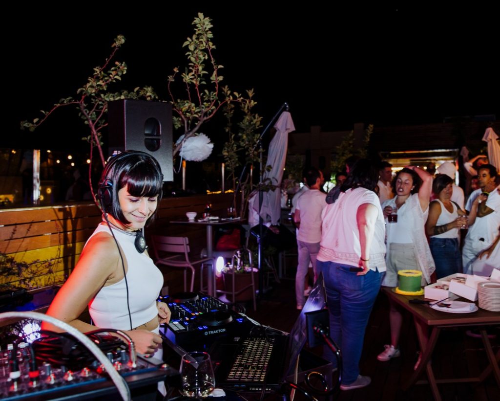 DJ Aleea mezclando música con invitados bailando al aire libre