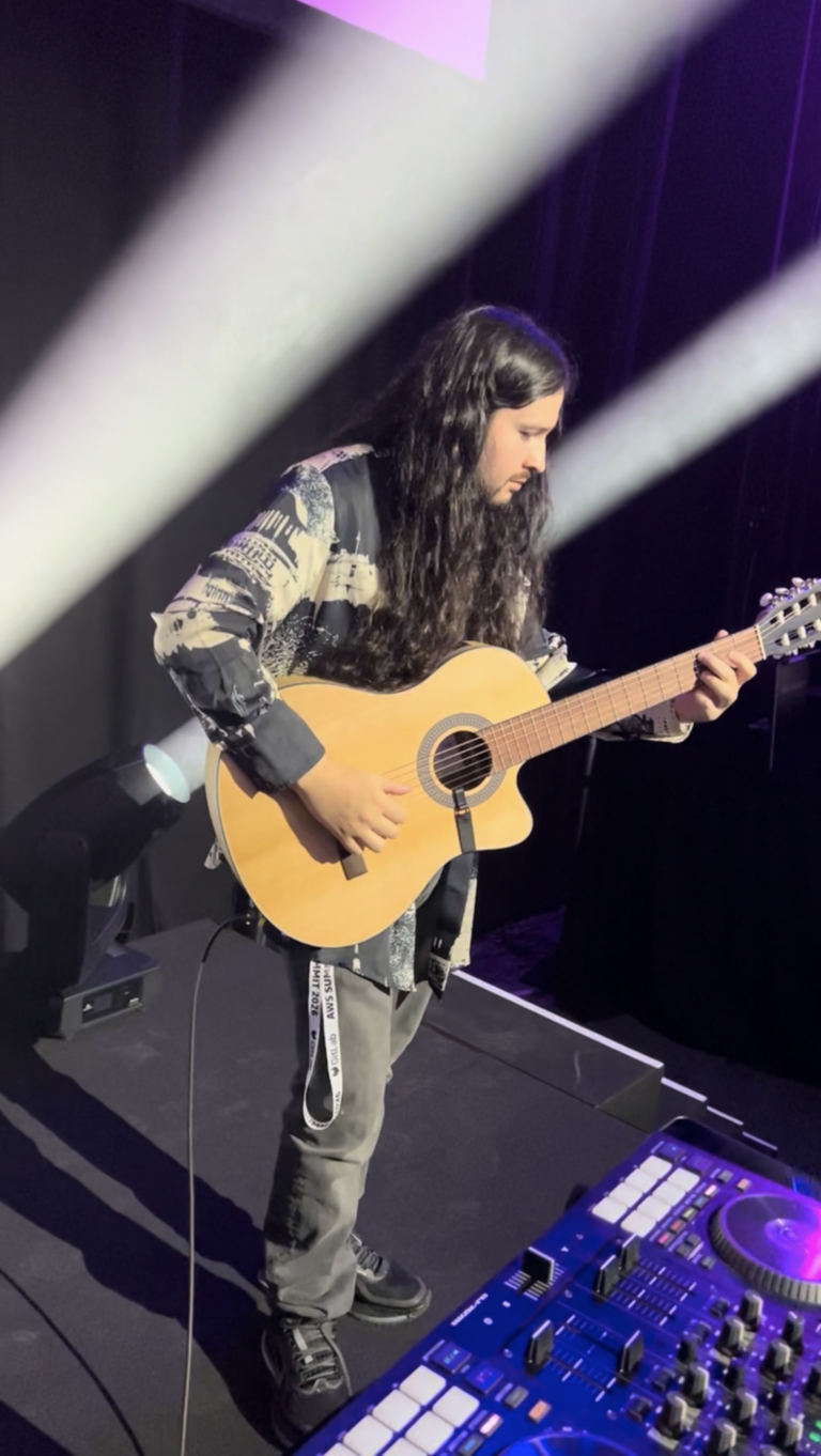 Guitarrista tocando una guitarra acústica en el escenario