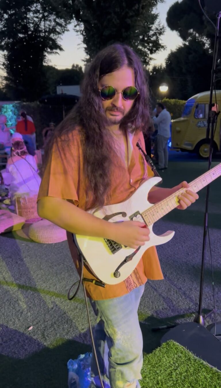 Guitarrista con guitarra eléctrica en una terraza